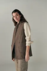 Chaleco color beige, entallado, con solapa, bolsillos plaqué y terminaciones envivadas.