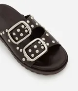 Sandalias planas flatform color marrón con puntera redonda, correas con hebillas plateadas y tachas redondas. Suela track.