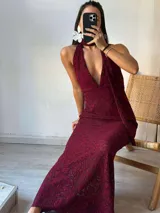 Vestido largo de encaje color borgoña, con escote halter y espalda descubierta.
