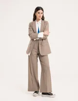 Blazer oversized de casimir 100% lana, de corte recto y largo a la cadera, con cierre delantero de dos botones y hombreras finitas.