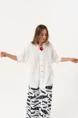 Camisa blanca con calados, escote en V, abotonada y manga 3/4.