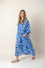 Vestido largo con estampado de peces azules sobre fondo blanco, cuello en V y mangas cortas.