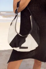 Cartera de cuero rojo con diseño contemporáneo y cierre lateral.