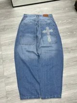 Pantalón de jean celeste con corte holgado, bolsillos cuadrados y bordado de cruz en el bolsillo trasero.