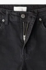 Pantalón de jean negro de corte ancho, tiro alto y largo tobillero.