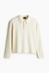 Remera polo de punto fino color crema, de manga larga con puños y bajo acanalados.