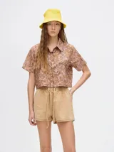 Short de denim color beige con cintura elastizada y cordón ajustable.