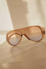 Lentes de sol con marco de policarbonato translúcido en color ámbar y diseño tipo aviador. Cuentan con cristales con protección UV400 y efecto degradado en tonos naranja y azul.