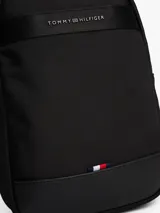 Bandolera Tommy Hilfiger negra de poliéster reciclado, con correa ajustable y logo metálico en el frente.
