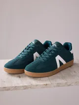 Championes de hombre color verde oscuro con detalles en blanco y suela marrón. Capellada de PU y textil, forro textil y suela de TPR.