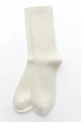 Calcetines largos color crema de tejido de punto acanalado.