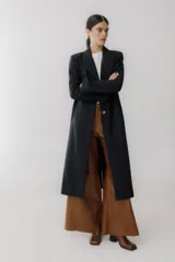 Tapado largo color beige, confeccionado en lana, con botones frontales y diseño contemporáneo.