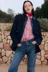 Pantalón de jean azul de corte recto, con tiro alto, cinco bolsillos y cierre con botones.