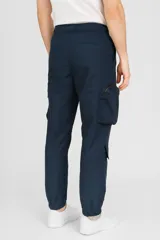 Pantalón babucha azul marino con cintura elástica ajustable con cordón y múltiples bolsillos tipo cargo.