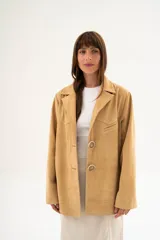 Blazer color beige de corte recto, con solapas y cierre con dos botones grandes.