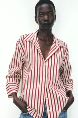 Camisa de manga larga con cuello solapa y cierre frontal con botones. Diseño a rayas verticales color borgoña y crema.