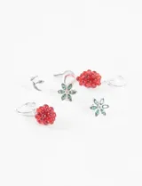 Set de tres pares de aros plateados: un par de aros tipo botón con forma de media luna, un par de aros tipo botón con forma de flor y cristales verdes, y un par de aros colgantes con forma de racimo de uvas rojas.