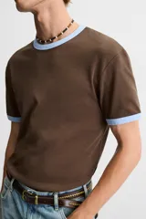 Camiseta azul marino de corte regular, cuello redondo y manga corta con ribete blanco en cuello y mangas.