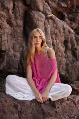 Poncho tejido de lino color fucsia, con diseño oversize y textura de punto abierto.