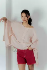 Blusa color rosa claro de lino con mangas anchas y ruedo con flecos.