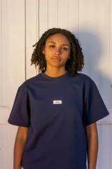 Remera azul marino de corte recto con logo pequeño en el pecho.