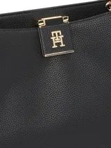 Cartera Tommy Hilfiger tipo tote color negro con textura granulada, doble asa corta, correa larga extraíble y ajustable, cierre magnético y logo metálico dorado en el frente.