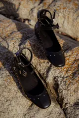 Balerinas negras de cuero con tachas y doble tira con hebillas plateadas.