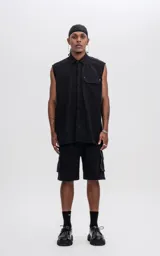 Camisa negra sin mangas de calce oversize con doble bolsillo y detalle de remaches en el frente, confeccionada en tejido twill de alta calidad.
