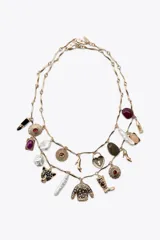 Set de dos collares dorados con cadena de eslabones y dijes colgantes con forma de labial, piedras de colores, zapatos de tacón, sweater, bota, candado de corazón, cabeza de pantera y perlas.