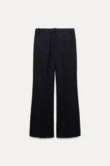 Pantalón de vestir de lana color azul marino, de tiro medio, con trabillas en la cintura, bolsillos frontales, pinzas delanteras y pierna recta.