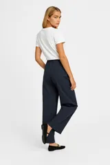 Pantalón de lino color beige, de corte ancho y tiro alto, con bolsillos laterales y cintura elastizada con cordón ajustable.