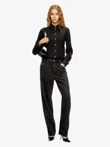 Overall de trabajo de denim negro lavado, con camisa de manga larga abotonada y pantalón de corte recto.