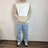 Canguro con capucha color marrón y beige, con logo bordado en el pecho y bolsillo tipo canguro.