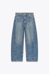 Pantalón de jean azul oscuro, tiro medio, corte amplio tipo baggy balloon con costuras torcidas y cinco bolsillos. Cierre frontal con cremallera y botón metálico.