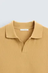 Polo azul marino de punto con textura acanalada vertical, corte regular fit, cuello solapa con abertura frontal y mangas cortas.