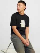 Remera negra de manga corta y cuello redondo con estampado rectangular con diseño abstracto en tonos beige y blanco.