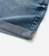 Short de jean azul oscuro, tiro alto, con bajo doblado y trabillas en la cintura.