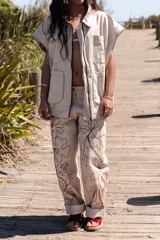 Pantalón slouchy color beige de gabardina de algodón con bordado floral marrón.