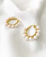 Par de aros tipo argolla dorados con cuentas blancas. Diámetro de 2cm y material de acero.