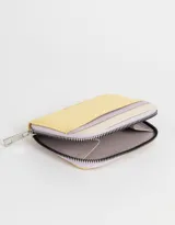 Billetera pequeña de cuerina color amarillo, lila y crema, con cierre de cremallera.