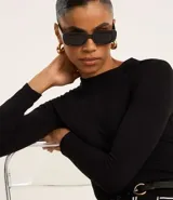 Blusa negra de mangas largas, confeccionada en viscosa sostenible, con cuello redondo y sisas raglán.