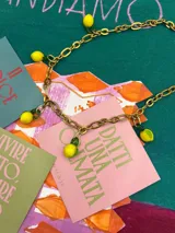 Collar dorado con cadena de eslabones y dijes colgantes de limones amarillos.