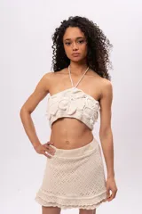 Top tejido a crochet color crudo, con diseño de flores en relieve y tirantes finos.