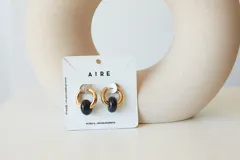 Aros de acero quirúrgico hipoalergénico con piedras naturales azules. Diseño de aro con dije circular colgante.