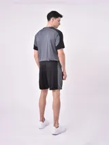 Short deportivo gris con paneles laterales negros y cintura elástica.