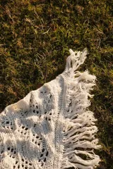 Bufanda triangular tejida en lana merino color marrón.