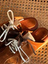 Zueco de cuero color marrón con cordones y suela de goma.