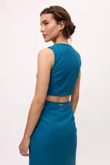 Vestido midi color fucsia, con corte a la cintura y falda tubo con tajo lateral. Presenta un top sin mangas con detalle cut-out en la cintura.