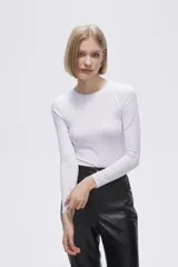 Remera gris de poliéster, de manga larga, corte ajustado y cuello redondo.