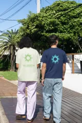 Remera color salmón con estampa en la espalda que incluye un sol y el texto "LA SIESTA TEMPORADA 2024".